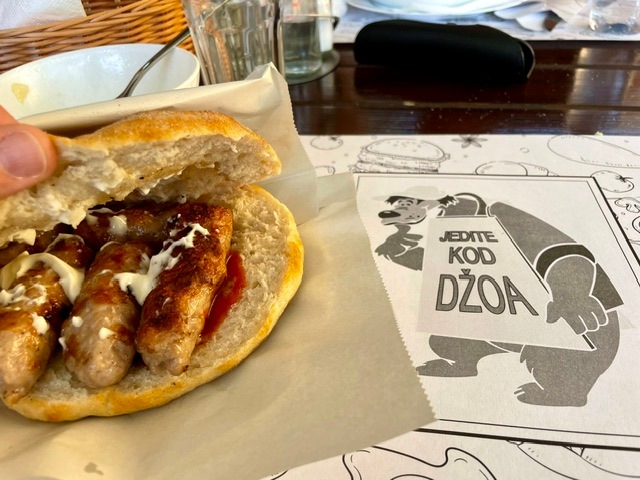 Traditional lunch of cevapi (meat fingers) in Harbour of Dobrota, Montenegro